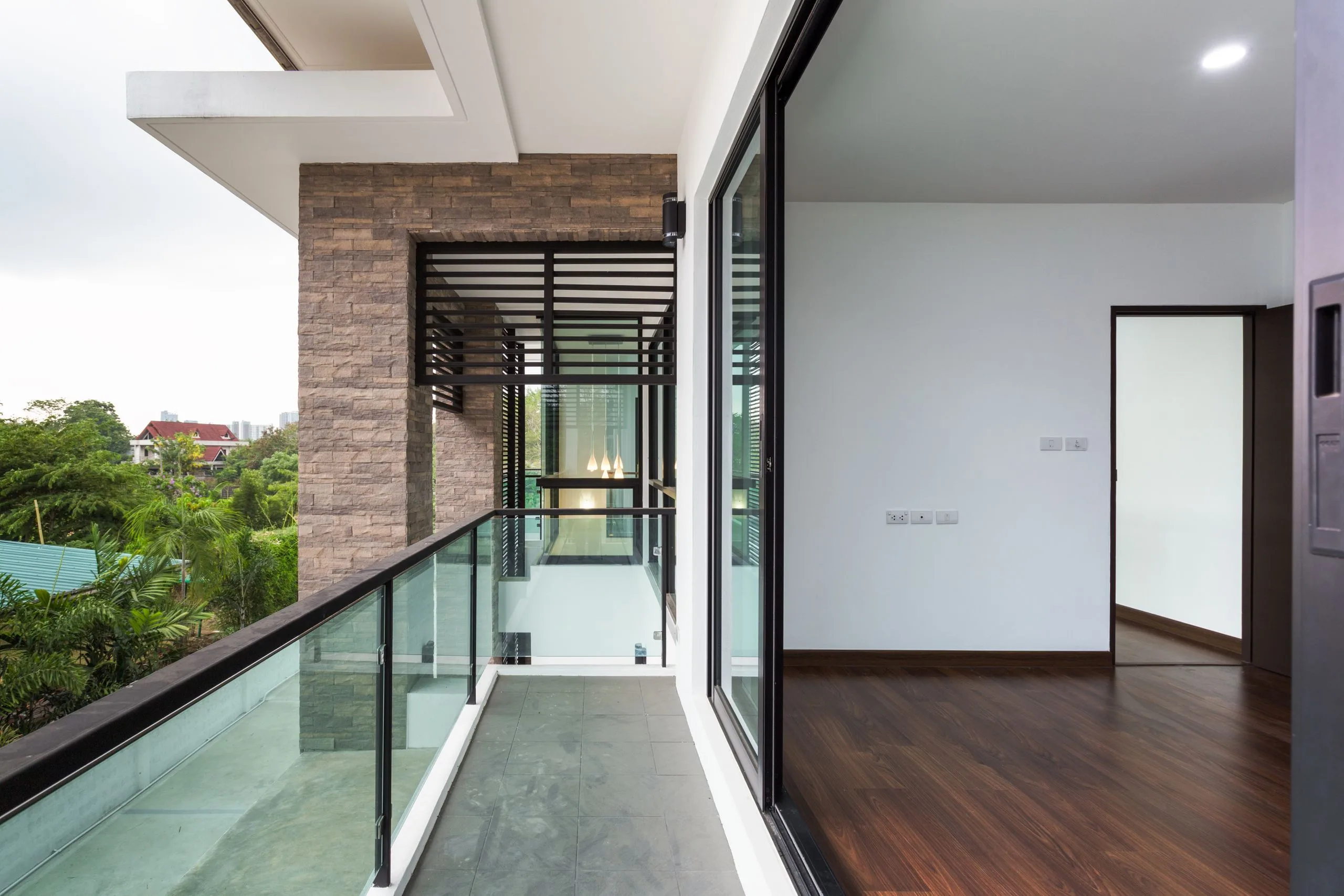 shutterstock_416008192-jpg A balcony with glass doors and a wood floor.